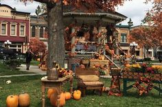 an outdoor gazebo decorated with pumpkins and flowers