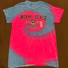 a pink and blue tie dye shirt with the word miami beach on it