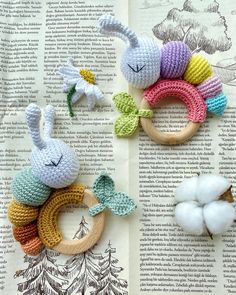 crocheted bunny rings and cotton balls on an open book with the pages in english