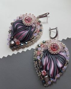 two pairs of earrings with pink and black designs