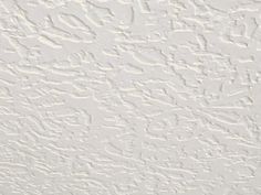 the textured wallpaper is white and has many small designs on it's surface