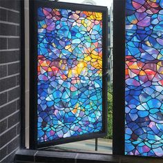 two colorful stained glass doors are open on the side of a building