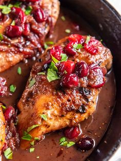 two pieces of meat with cranberry sauce in a cast iron skillet