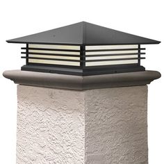 a light that is on top of a building with a white wall in the background