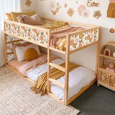 there is a bunk bed in the room with flowers on the wall and other decorations