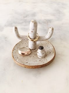 a white plate with two rings on it and a ring holder in the shape of an antelope