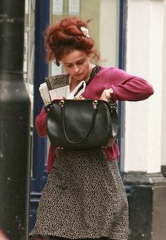 a woman walking down the street carrying a purse