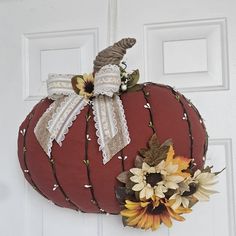 a decorative pumpkin hanging on the front door