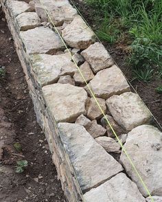 a stone wall is being built into the ground