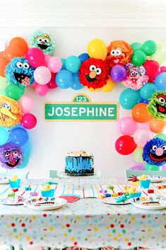 a sesame street birthday party with balloons and cake