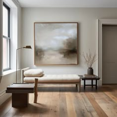 a living room with wood flooring and a painting hanging on the wall above it