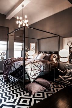 a bedroom with a four poster bed and black and white rugs on the floor