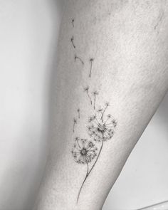 a small dandelion tattoo on the right leg, it is black and white