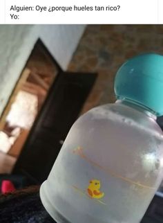 a baby bottle sitting on top of a bed next to a wall with an image of a rubber duck