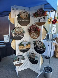 an outdoor display with wooden signs and wreaths on the sides, hanging from hooks