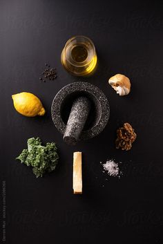 an assortment of ingredients including lemons, garlic and other items on a black surface