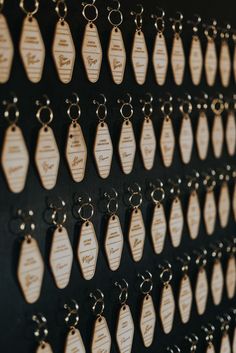 many tags are hanging on the wall with metal rings attached to each key chain,