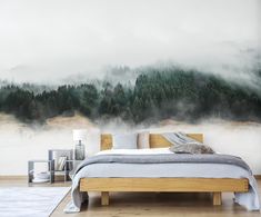 a bedroom with a mountain mural on the wall next to a bed and nightstands