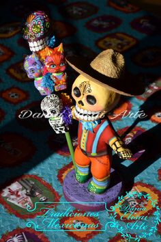 a small figurine is holding two skulls and a flower in it's hand