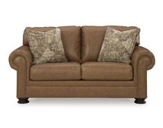 a brown leather couch with two pillows on it's back and one arm facing the camera