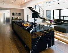 an open concept kitchen and living room with stairs