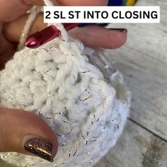 someone is holding a crochet ball with the words 2 st into closing