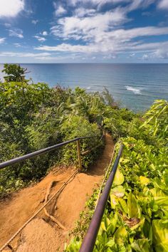 stairs leading down to the ocean on a sunny day with blue sky and white clouds