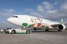 an airplane with hello kitty painted on the side is being towed by a tow truck