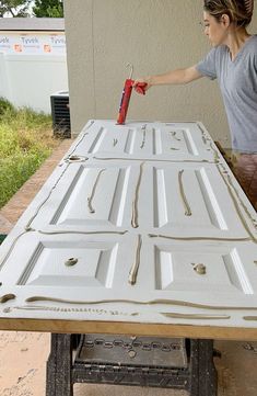 a woman is painting the outside of a table