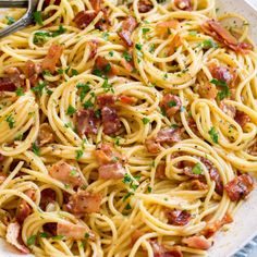 pasta with bacon and parsley in a white bowl