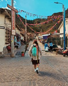 a woman with a backpack walking down a street