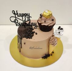 a birthday cake with chocolate frosting and sprinkles on top, sitting on a yellow plate