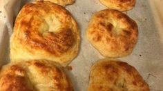 four rolls sitting on top of a pan covered in cheese