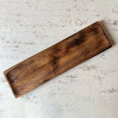 a wooden cutting board sitting on top of a white table