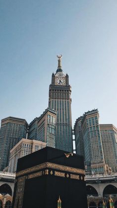 a tall building with a clock on it's side in front of other buildings