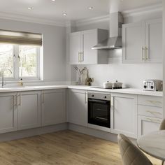 a kitchen with white cabinets and wooden floors