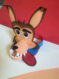 a paper mache of a dog with its mouth open and tongue out, sitting on top of a table