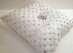 a white decorative pillow with lots of diamonds on it