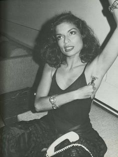 a woman sitting on the floor with her arm in the air and wearing a watch