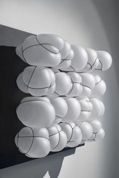 a bunch of white balloons hanging from the side of a wall