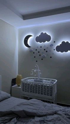 a baby's room with clouds and stars on the wall above the crib