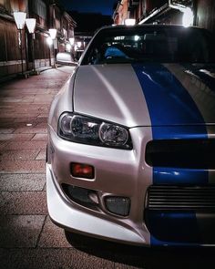 a silver and blue car is parked on the street