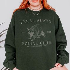 Welcome your a soon-to-be aunt with this feral aunts social club personalized pregnancy reveal auntie sweatshirt! This stylish t-shirt is perfect for announcing the big news. With a fun and trendy design, this custom shirt makes a fantastic gift for your sister, bestie, or sister-in-law and a memorable way to share your pregnancy reveal with the family. Whether it's for a special occasion or just to surprise her, this sweater is sure to make her feel special and excited about her new role as the Cool Aunt Aesthetic, Pregnancy Announcement To Sister, Pregnancy Reveal To Family, Pregnancy Announcement Aunt, Aunt Pregnancy Announcement, Aunt Sweater, Auntie Sweatshirt, Funny Sister Gifts, Baby Announcement Shirt