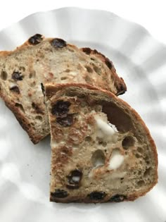 two slices of bread with raisins and cream on them sitting on a paper plate