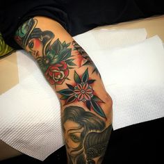 a woman's arm with tattoos and flowers on it