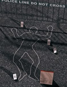 several yellow stickers on the ground near a fence with a drawing of a man