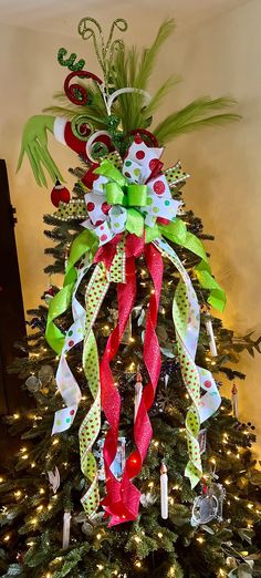 a christmas tree decorated with green, red and white ribbons