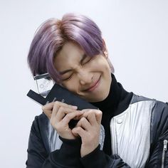 a person with purple hair holding a cell phone