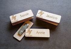 three wooden name tags with a razor blade on one side and another in the other