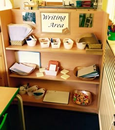 a book shelf filled with lots of books and writing supplies next to a desk full of papers